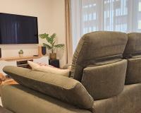 Modern nappali zöld kanapéval és növényekkel, fa bútorokkal – Attraktív Design Stúdió